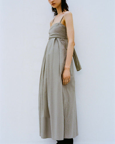 Cropped image of model standing against a white backdrop wearing the Claudine Dress in Tech Poplin in Sage