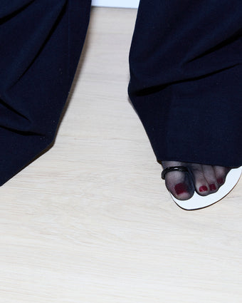 image of a model with red pedicure and black stockinged foot