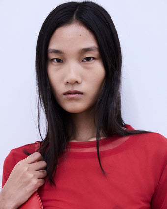 image of model Canlan Wang wearing red against a white backdrop at Spring Summer 2024 Show