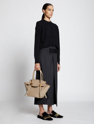 Image of model carrying Small Pipe Bag in LIGHT TAUPE