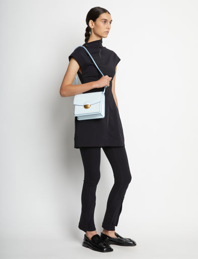 Image of model carrying Embossed Croc Dia Day Bag in pale blue