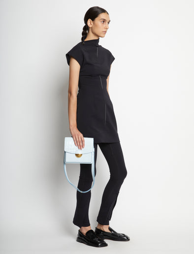 Image of model carrying Embossed Croc Dia Day Bag in pale blue