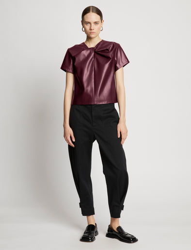 Front full length image of model wearing Faux Leather Twisted Top in PLUM