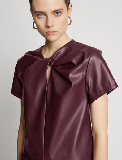 Detail image of model wearing Faux Leather Twisted Top in PLUM
