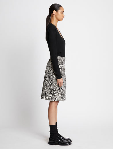 Side full length image of model wearing Eco Superfine Merino Scoop Neck Sweater in BLACK