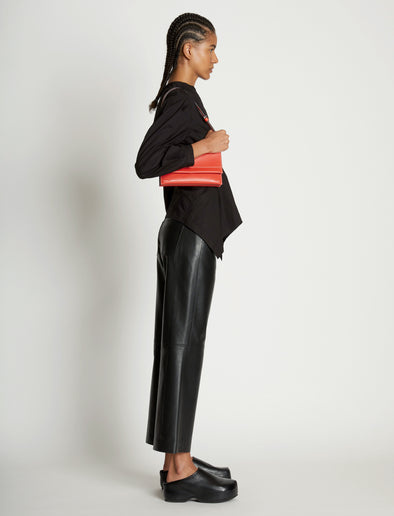 Image of model wearing Small Accordion Flap Bag in VERMILLION