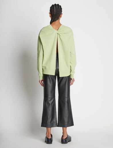 Back full length image of model wearing Long Sleeve Sweatshirt in GREEN TEA