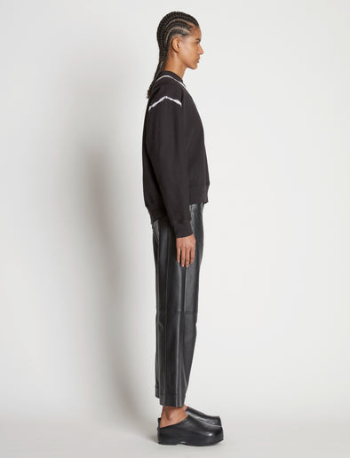 Side full length image of model wearing Tie Dye Sweatshirt in BLACK/OFF WHITE