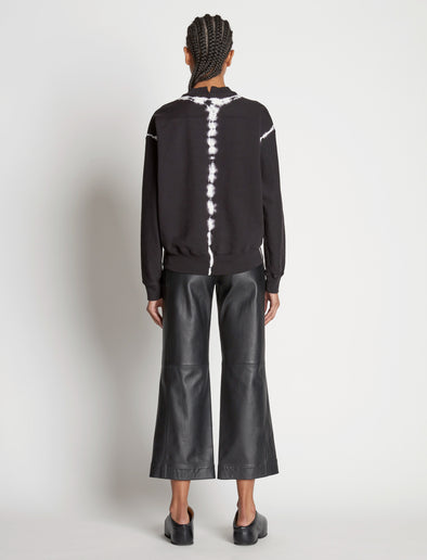 Back full length image of model wearing Tie Dye Sweatshirt in BLACK/OFF WHITE