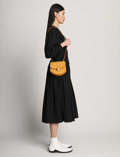 Side image of model carrying Mini Round Dia in CARAMEL