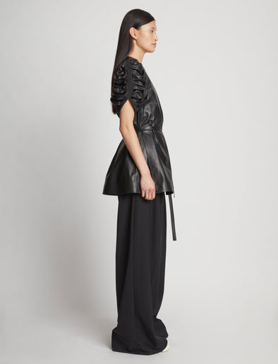 Side full length image of model wearing Leather Belted Top in BLACK