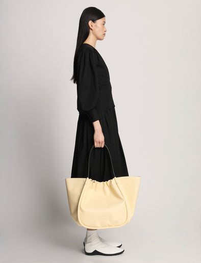 Side image of model wearing XL Ruched Tote in PALE YELLOW