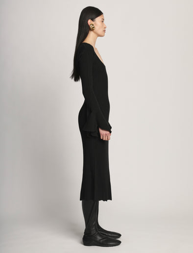 Side image of model wearing Fluted Rib Knit Dress in black