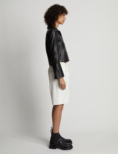 Side image of model wearing Faux Leather Shorts in off white