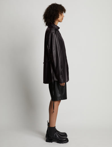 Side image of model wearing Faux Leather Shirt Jacket in black