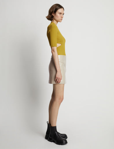 Side image of model wearing Vinyl Mini Skirt in fawn