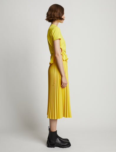 Side image of model wearing Faux Leather Pleated Midi Skirt in sun
