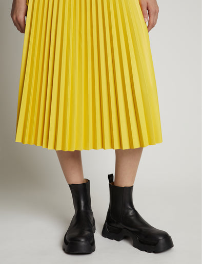 Detail image of model wearing Faux Leather Pleated Midi Skirt in sun