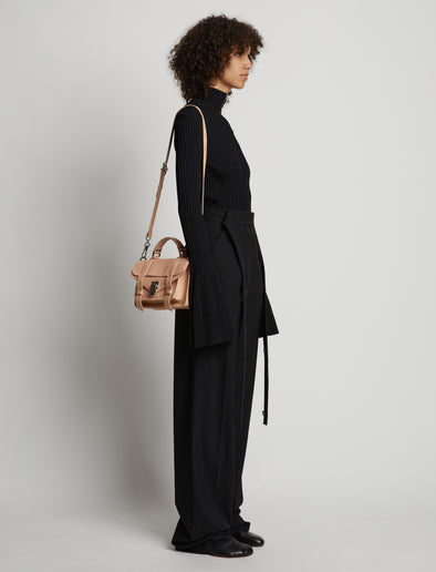 Image of model carrying Topstitch PS1 Tiny Bag in LIGHT NUDE