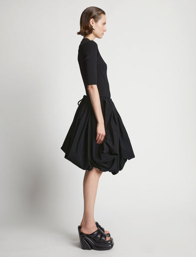 Side image of model wearing Technical Nylon Skirt in black