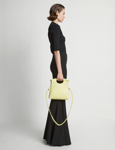 Image of model carrying Small Bar Bag in LEMONGRASS