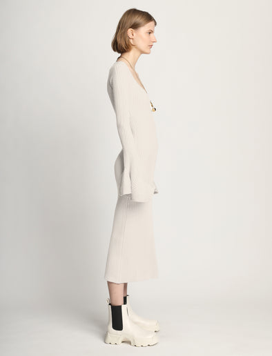 Side image of model wearing Fluted Rib Knit Dress in ivory