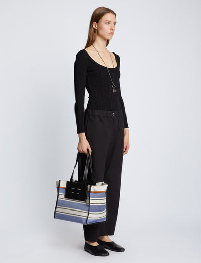 Image of model carrying Large Morris Stripe Canvas Tote in BLACK/WHITE/COBALT in hand