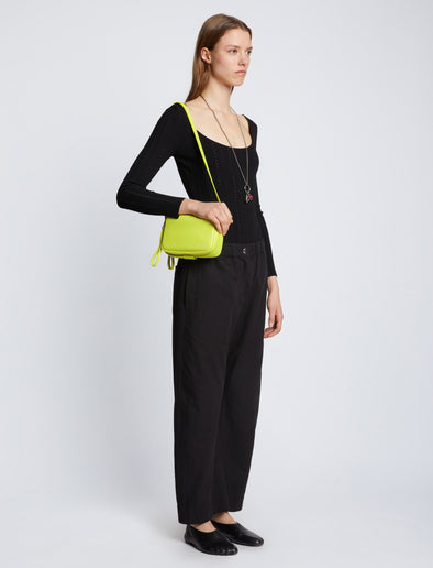 Side image of model carrying Watts Leather Camera Bag in LIME