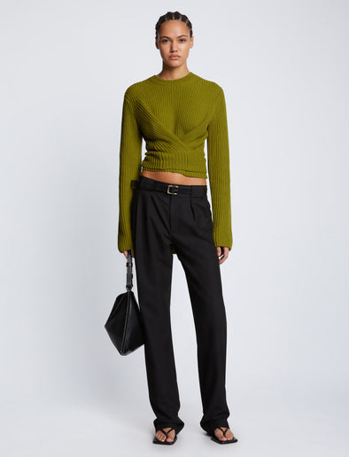 Front full length image of model wearing Ribbed Cotton Wrap Sweater in LEAF with straps tied around waist