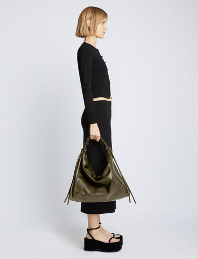 Image of model carrying Large Drawstring Shoulder Bag in OLIVE in hand