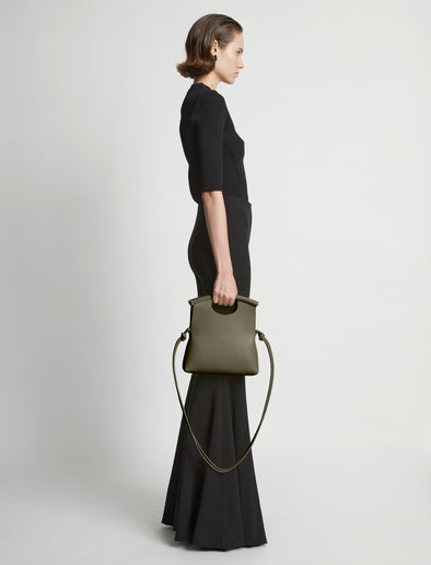 Image of model carrying Small Bar Bag in OLIVE in hand