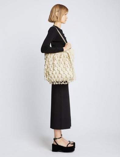 Image of model carrying Macrame Drawstring Tote in ECRU on shoulder