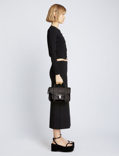Image of model carrying Carved Python PS1 Tiny Bag in BLACK