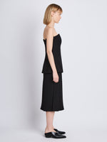 Side full length image of model wearing Corinne Strapless Top in BLACK