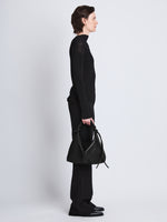 Image of model wearing Medium Drawstring Shoulder Bag in BLACK