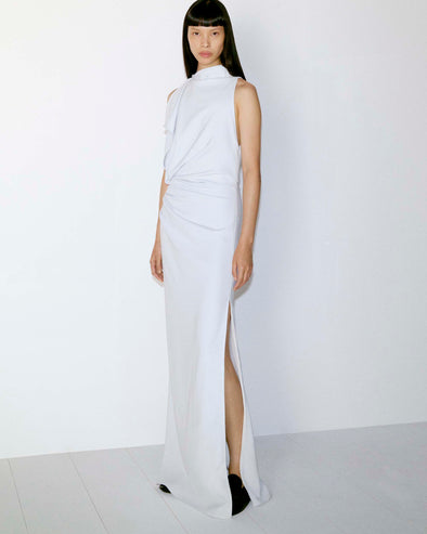 Model standing against white wall in Devyn Dress in Matte Double Crepe in Powder Blue