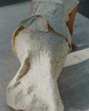 Image of model crawling on carpet wearing Chrysanthemum Jacquard skirt and vest
