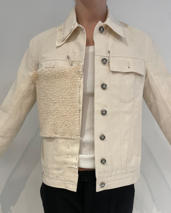 4x5 iPhone image of the Sylvie Jacket in fittings, with a canvas prototype worn on model and a boucle fabric swatch pinned to the canvas jacket