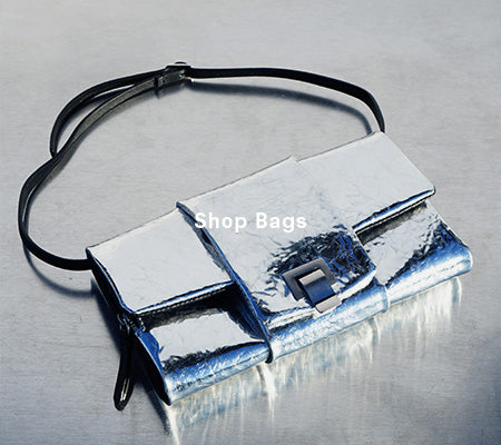 Aerial image of Flip Shoulder Bag in Crinkled Metallic in silver on tonal silver backdrop, 'Shop Bags' overlaid