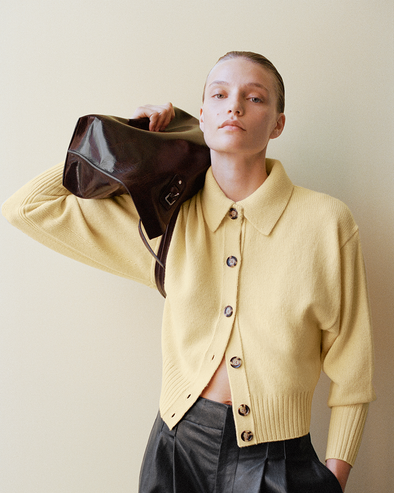 Proenza Schouler Front cropped image of model wearing Rocio Cardigan in Cashmere in Pale Yellow holding the Days Tote