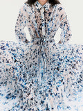Cropped image of model standing in front of a white backdrop, wearing Jones Dress in Printed Crinkle Chiffon in Sky Blue Multi