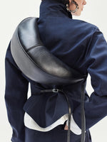 Cropped image of model standing against white backdrop Slide bag in Black and Thelma Jacket in Cotton Linen Suiting in Navy