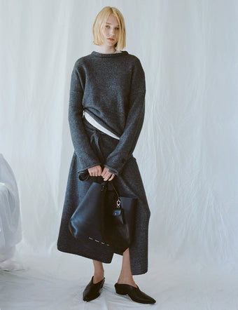 Model wearing Tara Sweater and Zaydie Wrap Skirt in dark grey melange, holding black Bedford Tote
