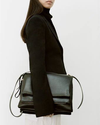 Cropped profile image of model carrying City Bag in black