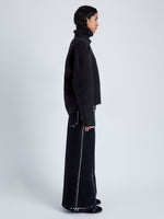 Side full length image of model wearing Yara Sweater In Double Face Cashmere in Black