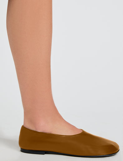 Image of model wearing Glove Slippers in Slick Nappa in Mud