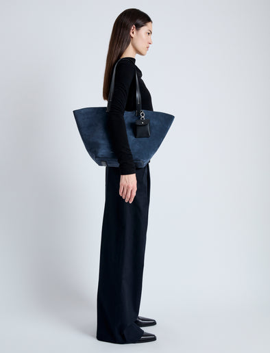 Image of model carrying Large Bedford Tote in Suede in navy/black