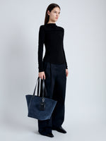 Image of model carrying Large Bedford Tote in Suede in navy/black