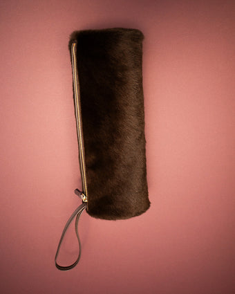 Image of the Silo Clutch in Chocolate Shearling on a light pink background