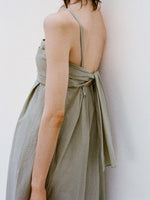 Cropped image of model's side standing against a white backdrop wearing the Claudine Dress in Tech Poplin in Sage